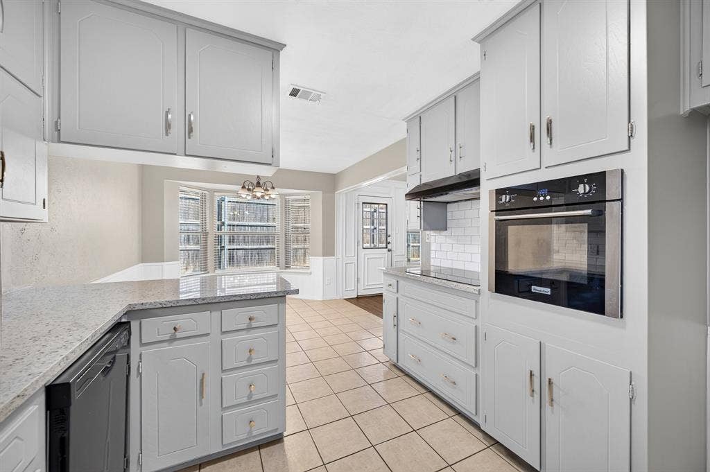912 Shell Court, Bedford, TX 76022 Kitchen featuring light-toned cabinetry, granite-style countertops, an integrated wall oven, subway tile backsplash, and tile flooring
