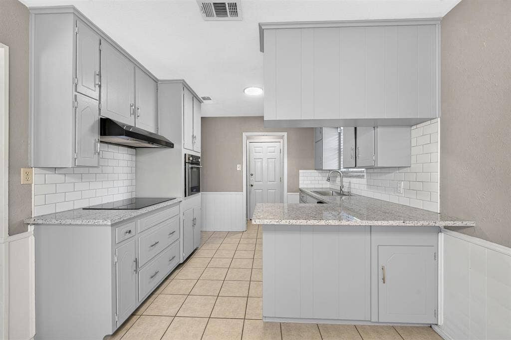912 Shell Court, Bedford, TX 76022 Kitchen featuring gray cabinetry, light-toned countertops, white subway tile backsplash, and tile flooring