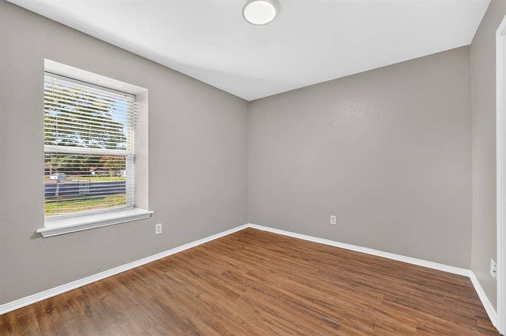 912 Shell Court, Bedford, TX 76022 Neutral-toned walls, wood-finish flooring, and a window with blinds