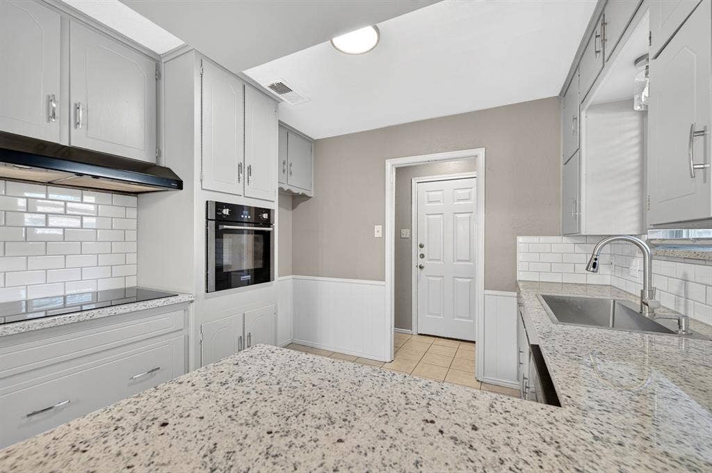 912 Shell Court, Bedford, TX 76022 Granite countertops, white subway tile backsplash, stainless steel double basin sink, and built-in wall oven