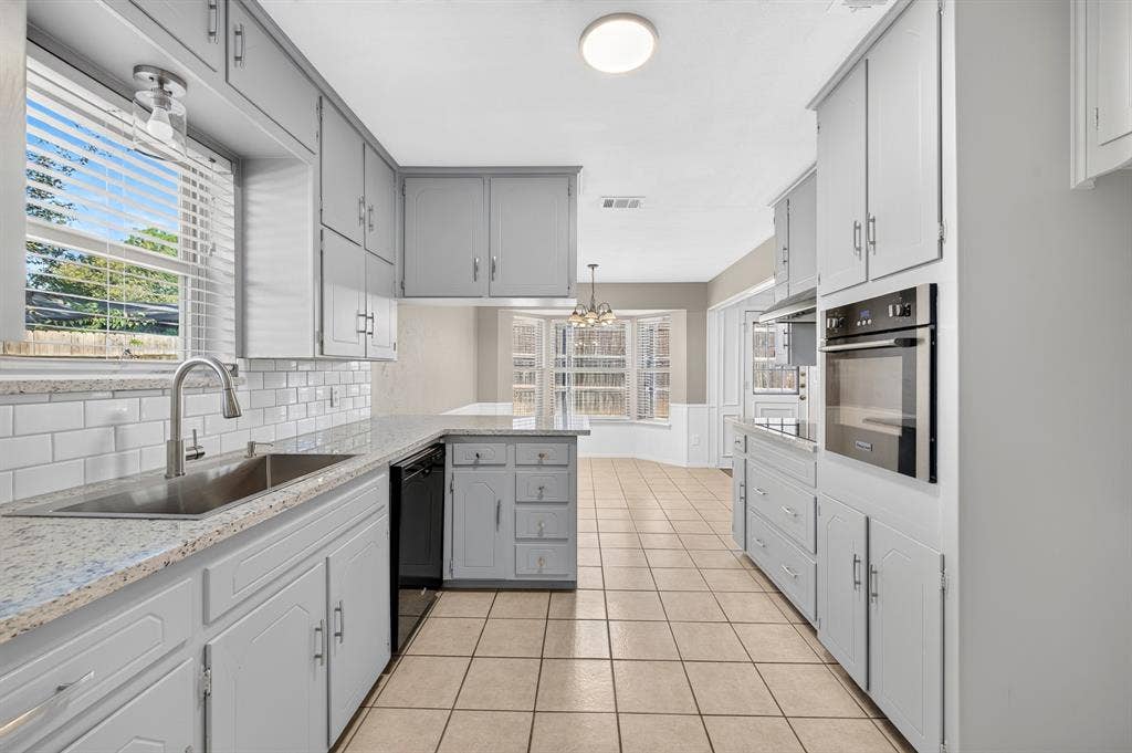 912 Shell Court, Bedford, TX 76022 Kitchen featuring a stainless steel sink, subway tile backsplash, light-colored countertops, built-in oven, and tile flooring