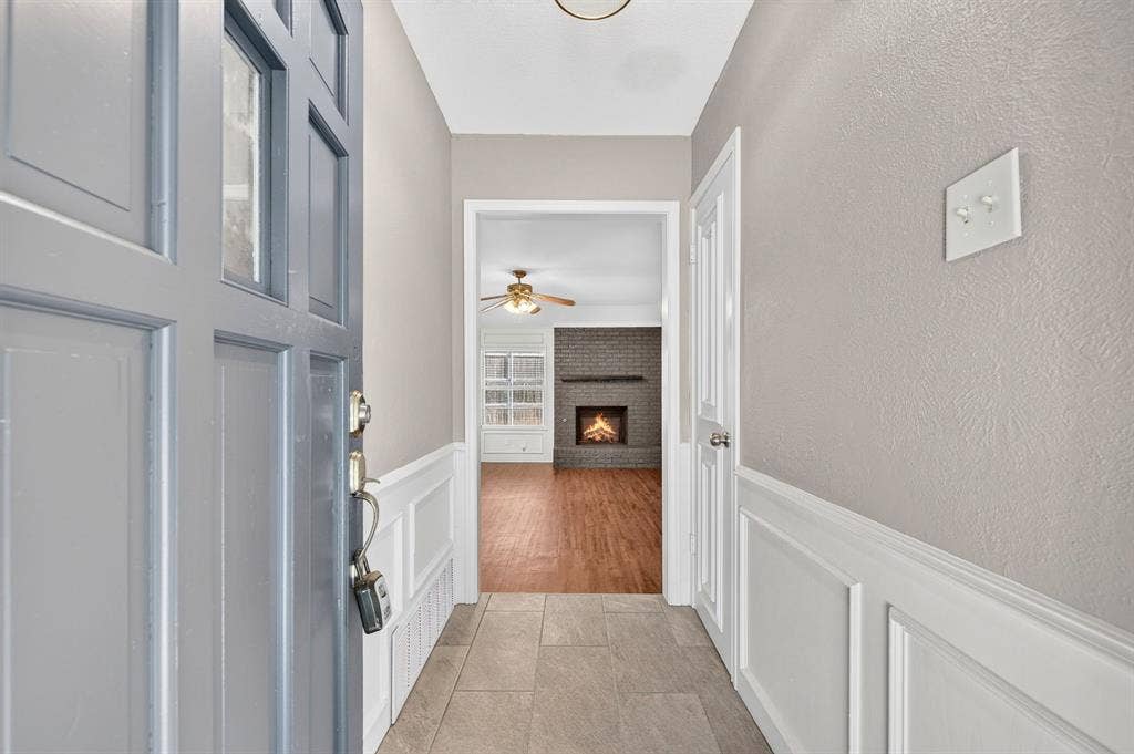 912 Shell Court, Bedford, TX 76022 Panel-style front door with glass inserts, tile flooring, and wainscoting details