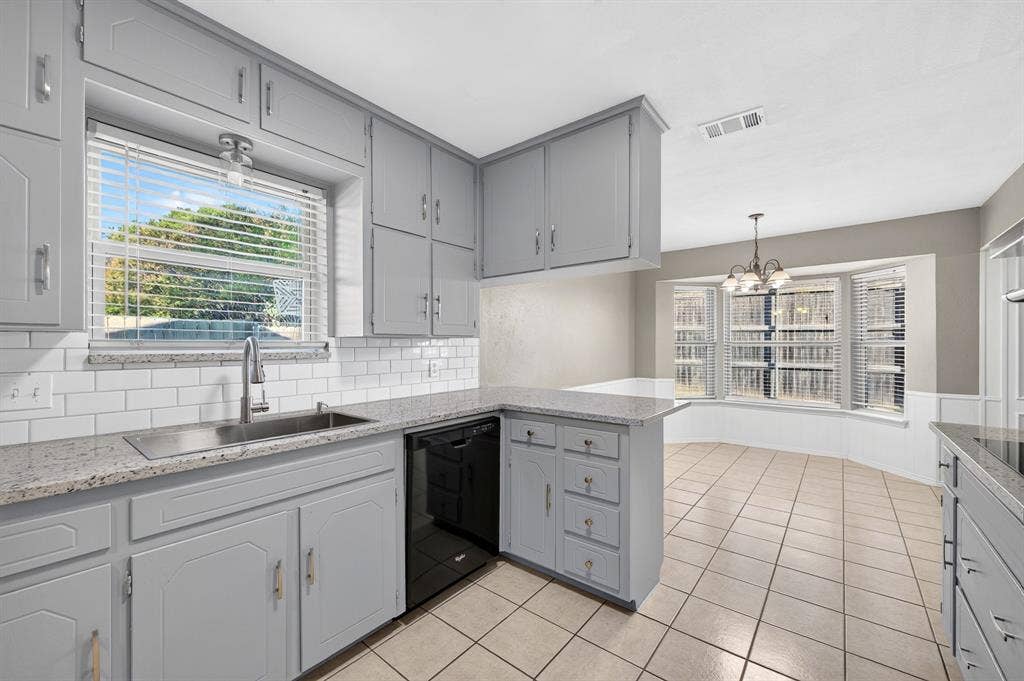 912 Shell Court, Bedford, TX 76022 Light gray cabinetry with brushed nickel hardware, white subway tile backsplash, light granite-style countertops, stainless steel sink with gooseneck faucet, and tiled flooring