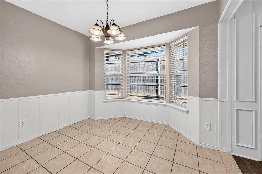 912 Shell Court, Bedford, TX 76022 Bay window with slatted blinds, white wainscoting, neutral wall paint, ceiling-mounted light fixture, and ceramic tile flooring