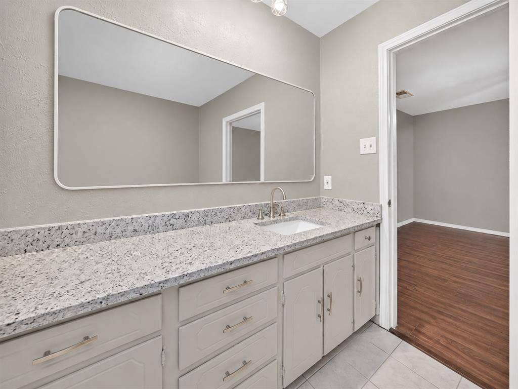 912 Shell Court, Bedford, TX 76022 Spacious vanity with light-toned cabinetry, a built-in sink, and a speckled countertop