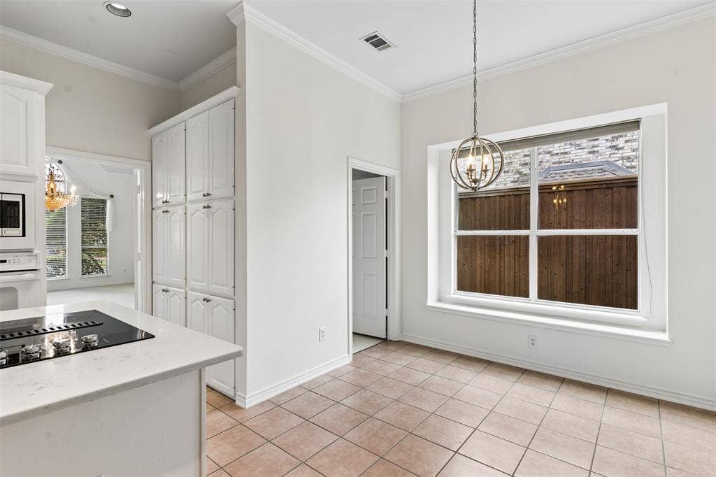 327 Hampton Court, Coppell, TX 75019 Kitchen area featuring tile flooring, white cabinetry, a stone-finish countertop with an integrated stovetop, and a suspended orb chandelier