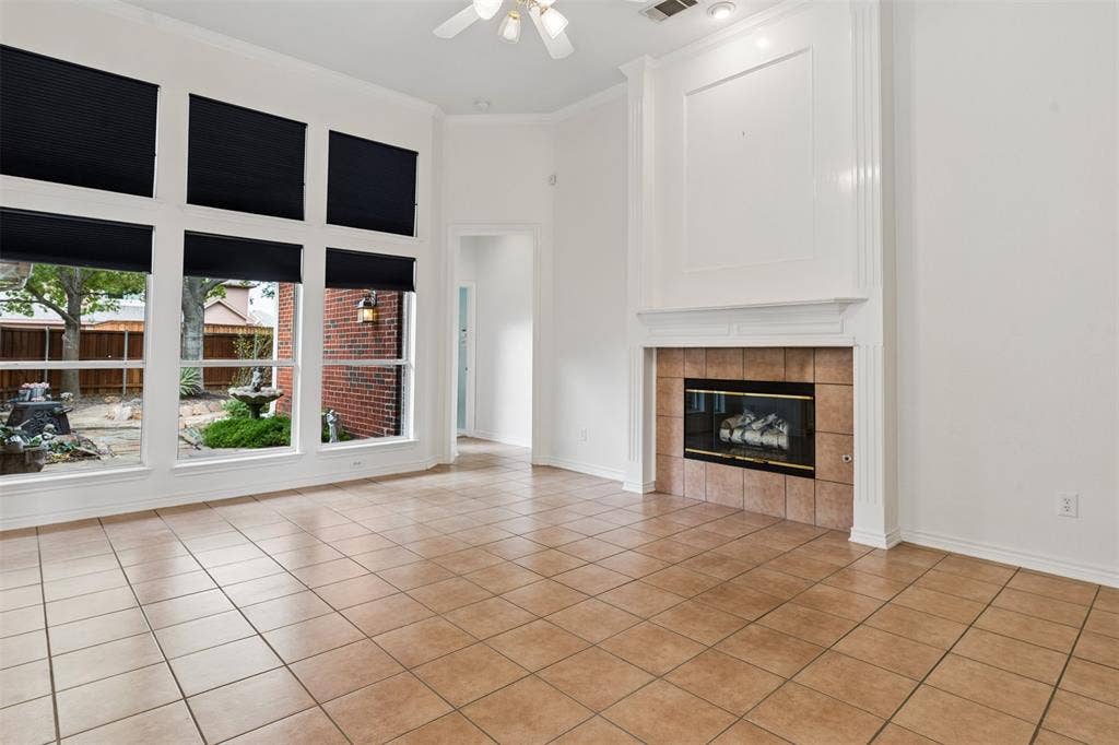 327 Hampton Court, Coppell, TX 75019 Living area featuring tile flooring, a fireplace with a ceramic tile surround and mantel, and expansive windows