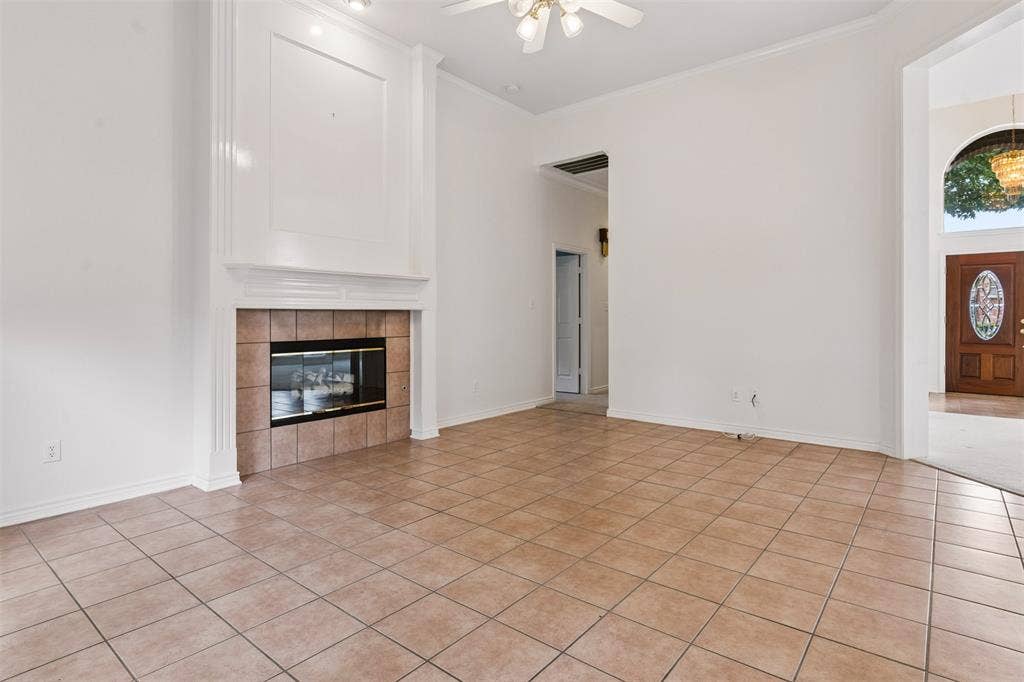 327 Hampton Court, Coppell, TX 75019 family room area featuring tile flooring, high ceilings with a central fan, and a floor-to-ceiling fireplace mantel with tile surround