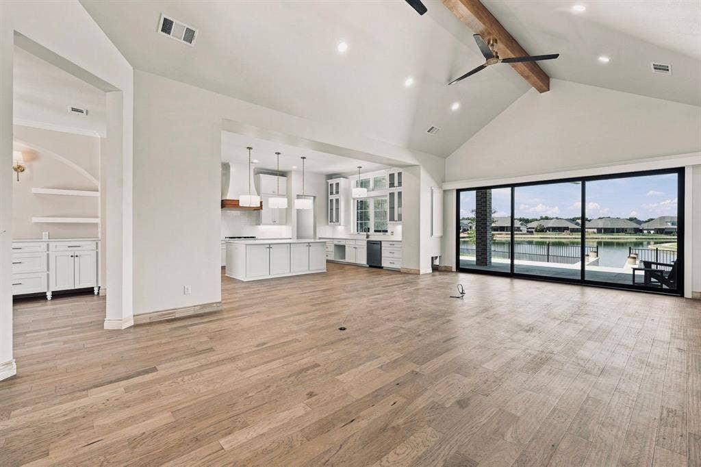 6651 Pinehurst Drive, Granbury, TX 76049 Vaulted ceiling with exposed beam, wood-finish flooring, recessed lighting, and expansive sliding glass doors