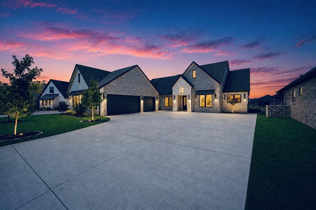 6651 Pinehurst Drive, Granbury, TX 76049 Stone façade residence featuring multiple gables, a three-car garage, and an expansive concrete driveway