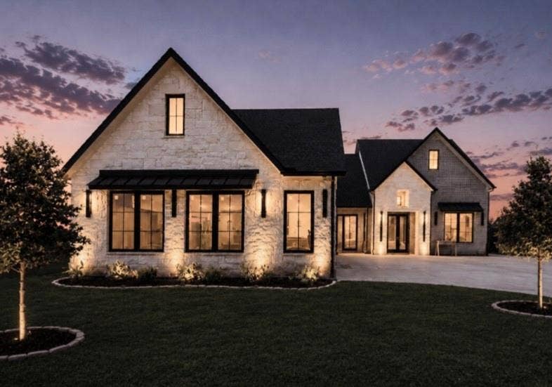 6651 Pinehurst Drive, Granbury, TX 76049 Stone exterior with a black roof, large windows, and a prominent front entrance