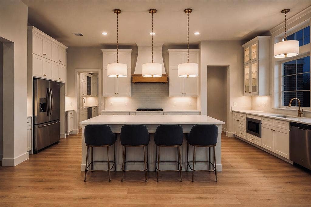 6651 Pinehurst Drive, Granbury, TX 76049 Gourmet kitchen with wood-finish flooring, white cabinetry, a large island with seating, a stainless steel refrigerator, and recessed lighting