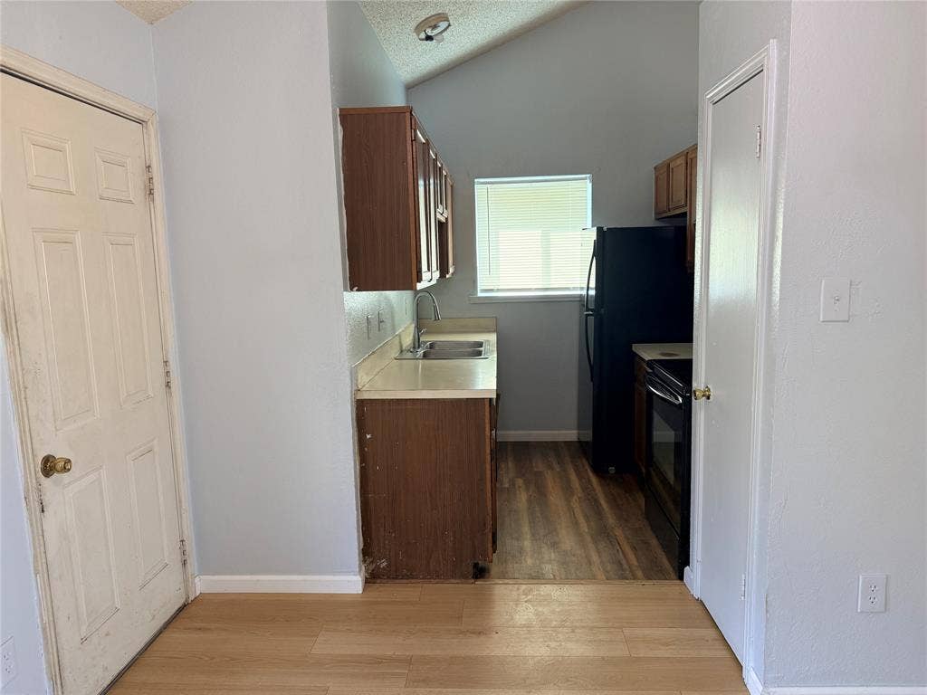 1644 Taylorcrest Drive, Dallas, TX 75253 Kitchenette with wood-finish flooring, vaulted ceiling, and built-in cabinetry