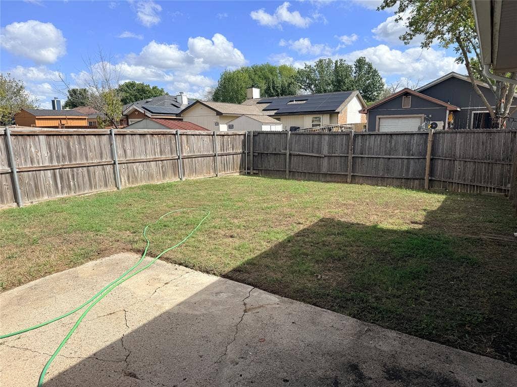1644 Taylorcrest Drive, Dallas, TX 75253 Expansive backyard featuring a wood privacy fence, concrete patio, and a grass lawn
