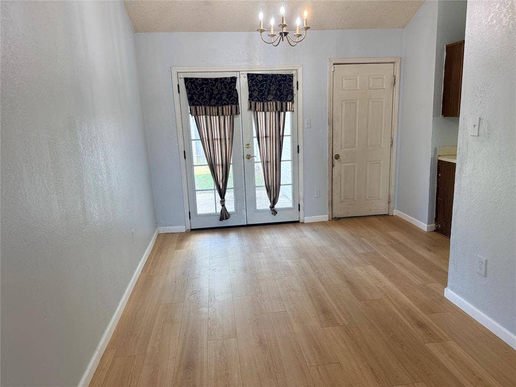 1644 Taylorcrest Drive, Dallas, TX 75253 Light wood-finish flooring with a multi-paneled double door and a chandelier light fixture