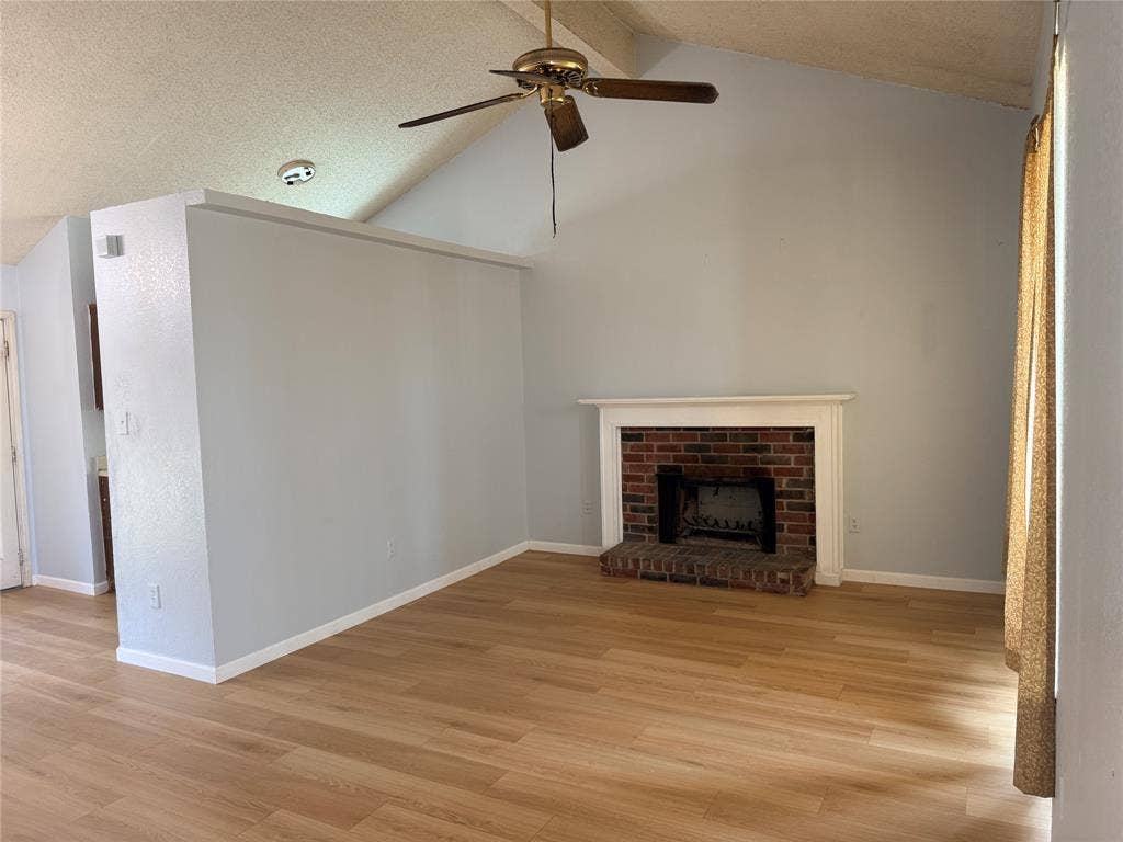 1644 Taylorcrest Drive, Dallas, TX 75253 Vaulted ceilings with a ceiling fan, brick fireplace with a white mantel, and wood-finish flooring