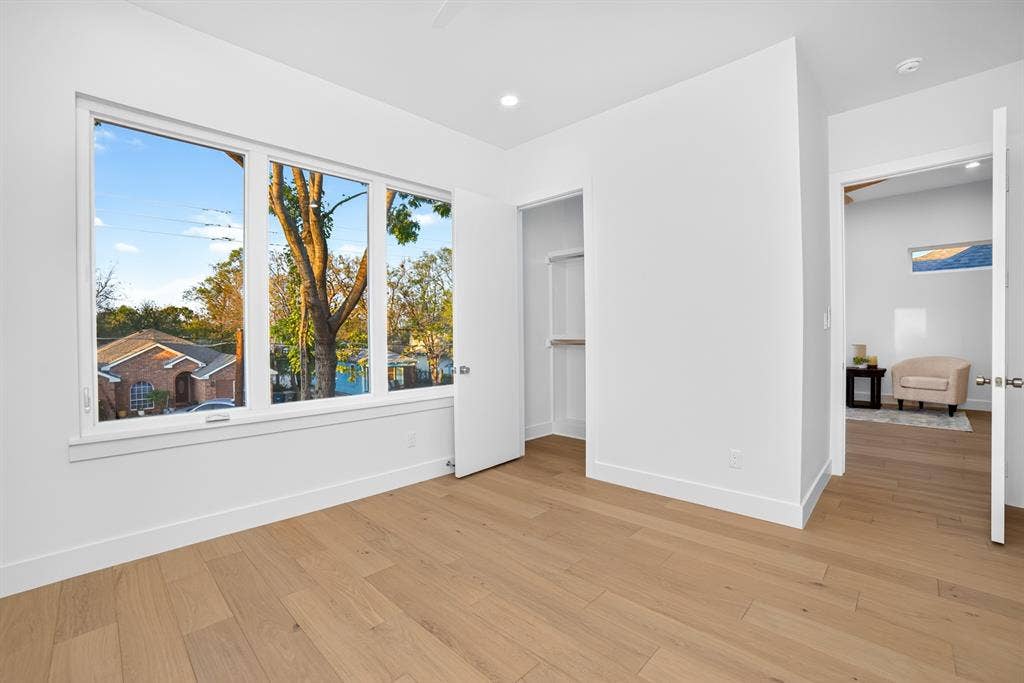 Large picture windows, wood-finish flooring, recessed lighting, and a built-in closet