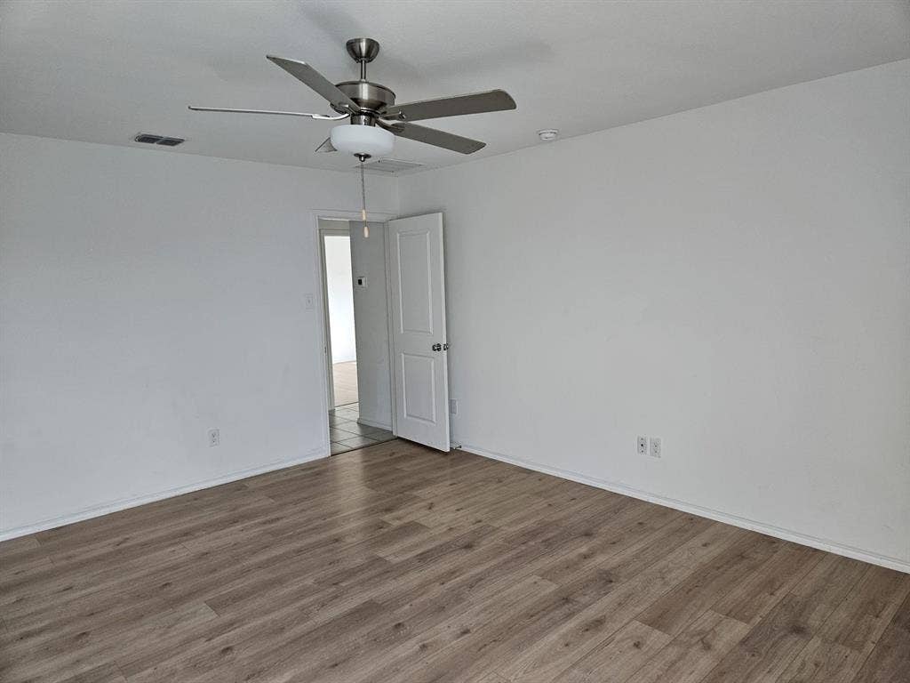 3338 Beckwith Way, Crandall, TX 75114 Wood-finish flooring with crisp white walls and ceiling