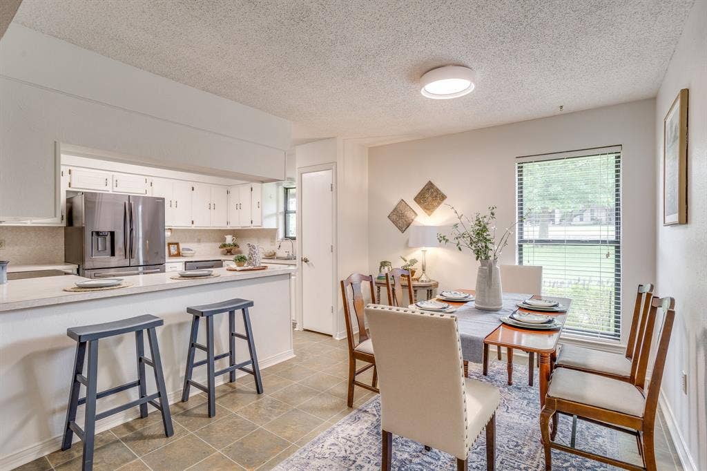 Kitchen bar with light-toned countertop and eat-in kitchen/dining area