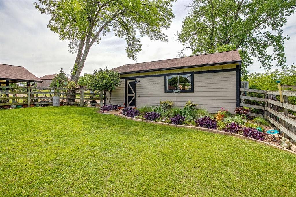 Expansive lawn area with a detached shed featuring horizontal siding and a shingled roof