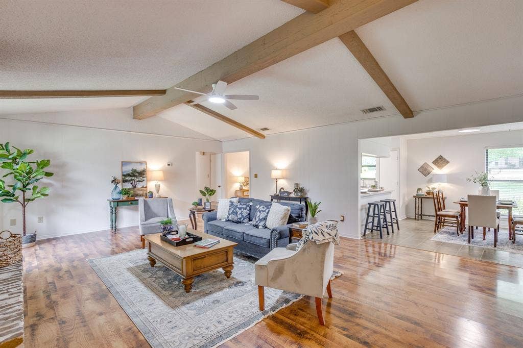 Vaulted ceiling with exposed wood beams, wood-finish flooring, recessed lighting, ceiling fan, and an open concept layout