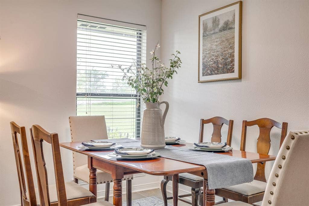 Bright dining area with a window featuring horizontal blinds