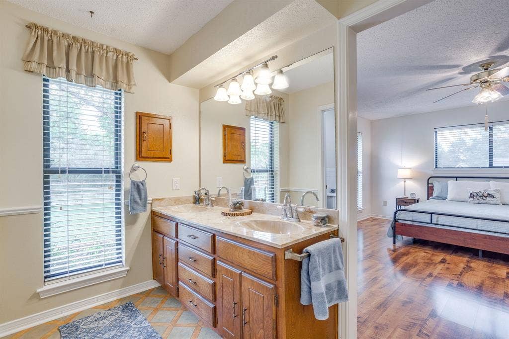 Bathroom featuring a dual vanity with a light-colored countertop and wood-finish cabinetry
