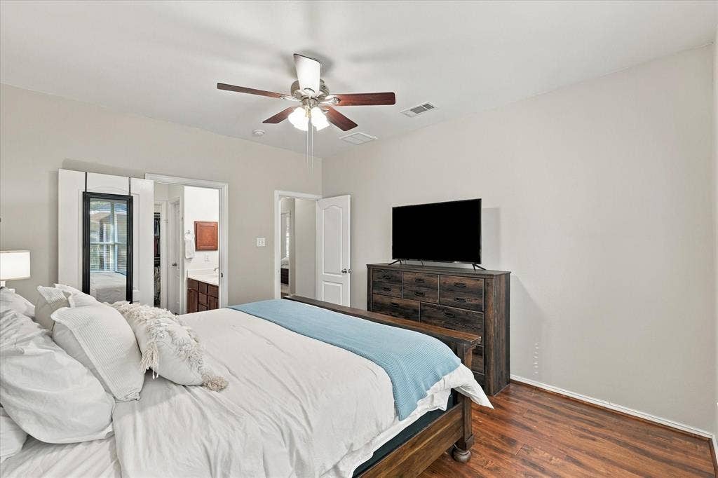 Wood-finish flooring, ceiling fan, and light neutral wall color