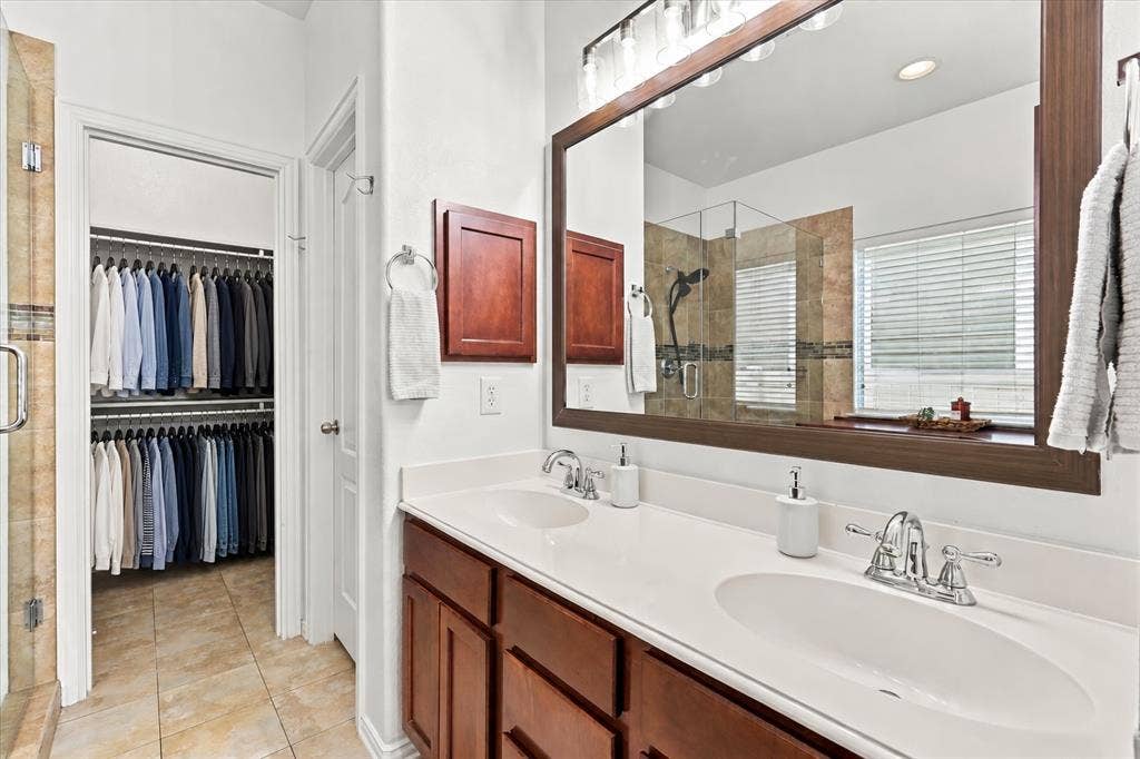 Dual vanity with undermount sinks, chrome fixtures, and a large framed mirror