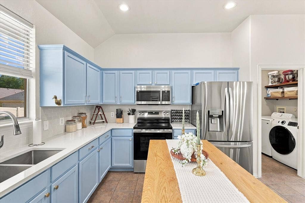 Kitchen featuring light blue cabinetry, stainless steel appliances, a double basin sink, recessed lighting, and a pantry with built-in shelving
