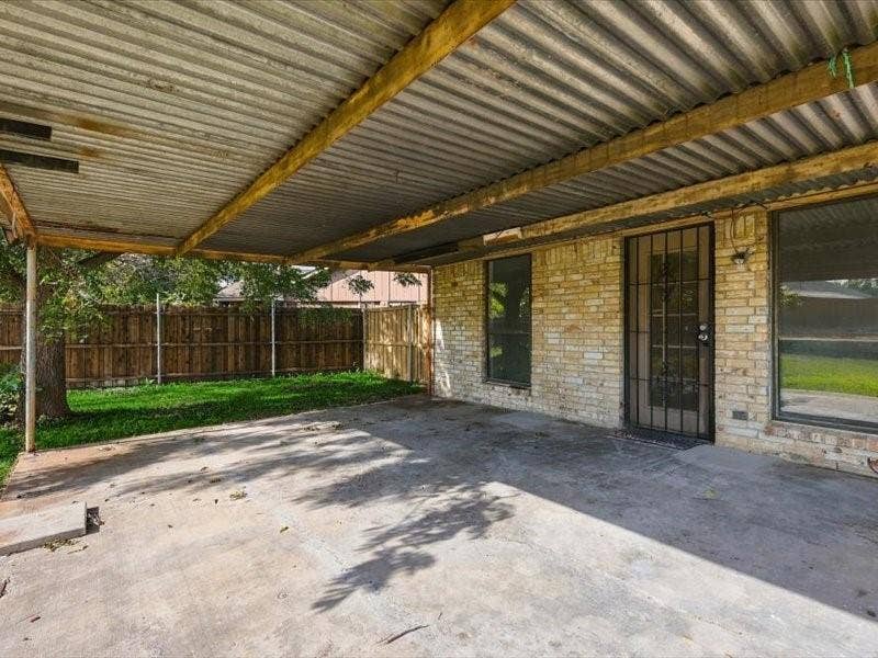 725 Southridge Court, Grand Prairie, TX 75052 Covered patio area with a concrete surface, a corrugated metal roof, and a brick exterior wall
