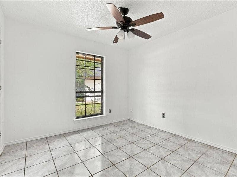 725 Southridge Court, Grand Prairie, TX 75052 Tile flooring, white walls, black-framed window, and a ceiling fan with light fixture
