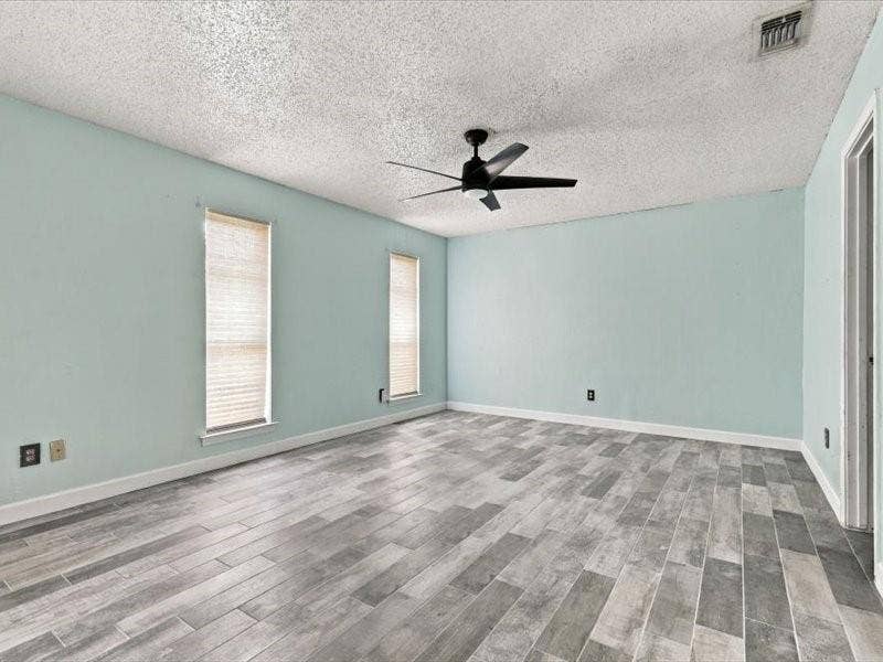 725 Southridge Court, Grand Prairie, TX 75052 Wood-finish tile flooring, a ceiling fan, and two windows with blinds