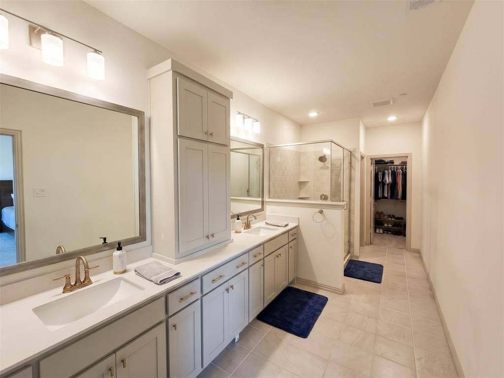 Dual-sink vanity with light-tone cabinetry, quartz countertops, and brushed metal fixtures