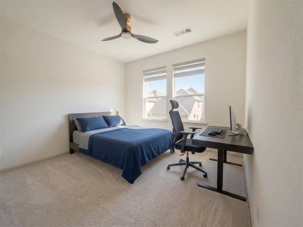 Neutral-toned wall-to-wall carpeting, dual-pane windows with roller shades, and a three-blade ceiling fan