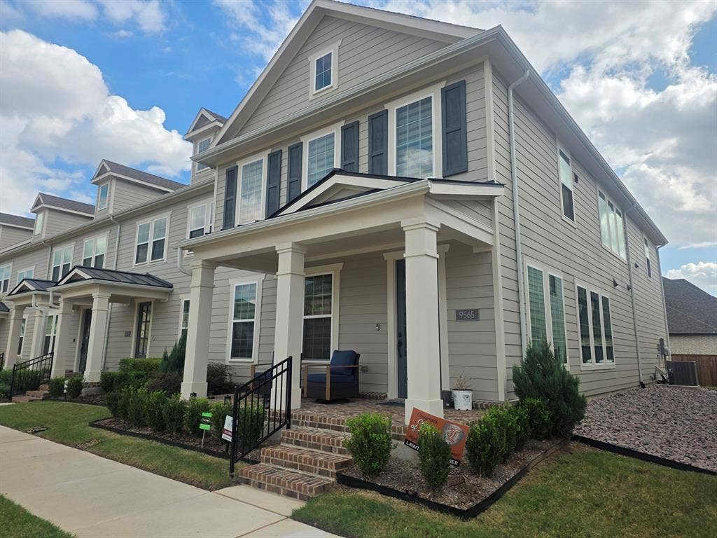 Multi-level exterior featuring horizontal lap siding, a covered front porch with square columns, brick-stair entry, dark shutters, and tiered gabled rooflines