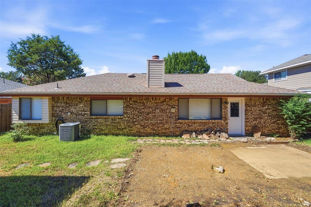 Brick exterior with brown shingle roofing and white trim