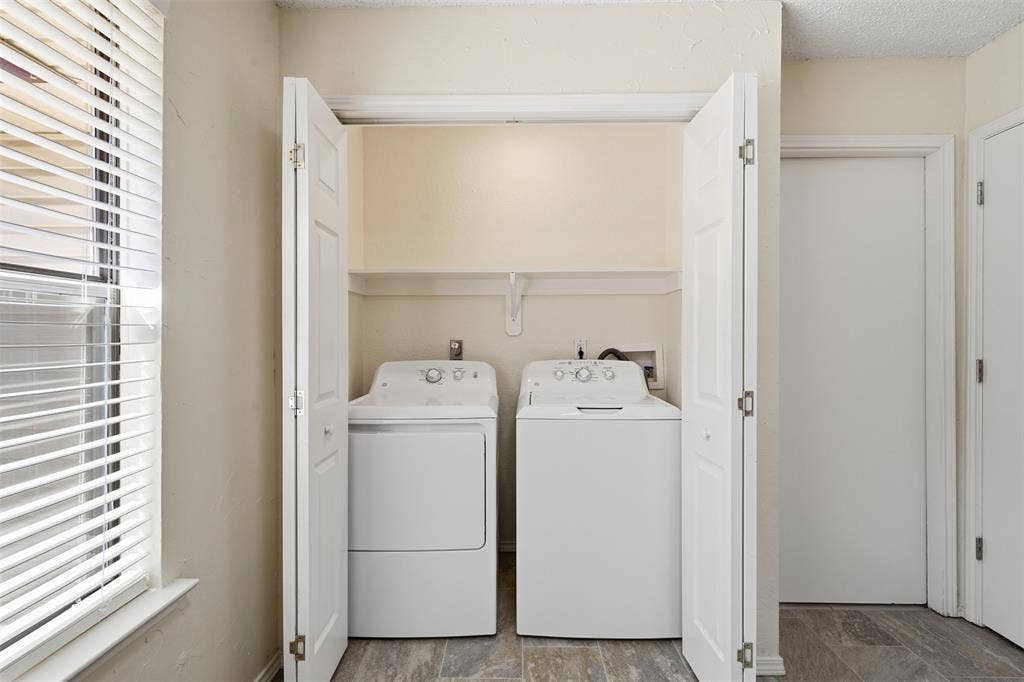Laundry closet with bi-fold doors, overhead shelving, and wood-finish flooring
