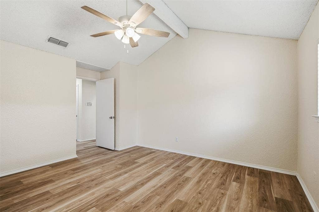Wood-finish flooring with white baseboards and light-colored walls