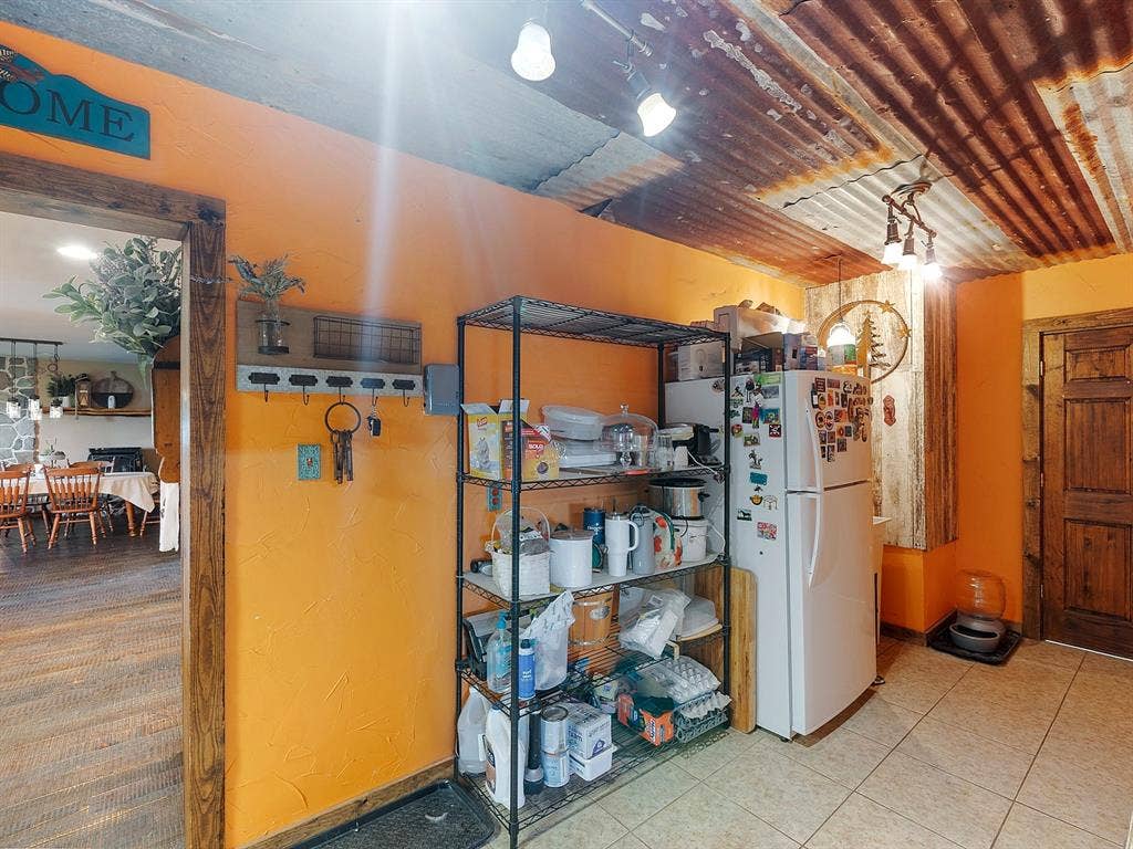 5801 County Road 4128, Scurry, TX 75158 Corrugated metal ceiling featuring multi-light track lighting, textured walls, and a solid wood door with natural finish trim