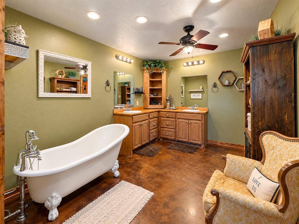 5801 County Road 4128, Scurry, TX 75158 Freestanding clawfoot tub, dual vanity with wood cabinetry, ceiling fan, recessed lighting, and rich floor finish