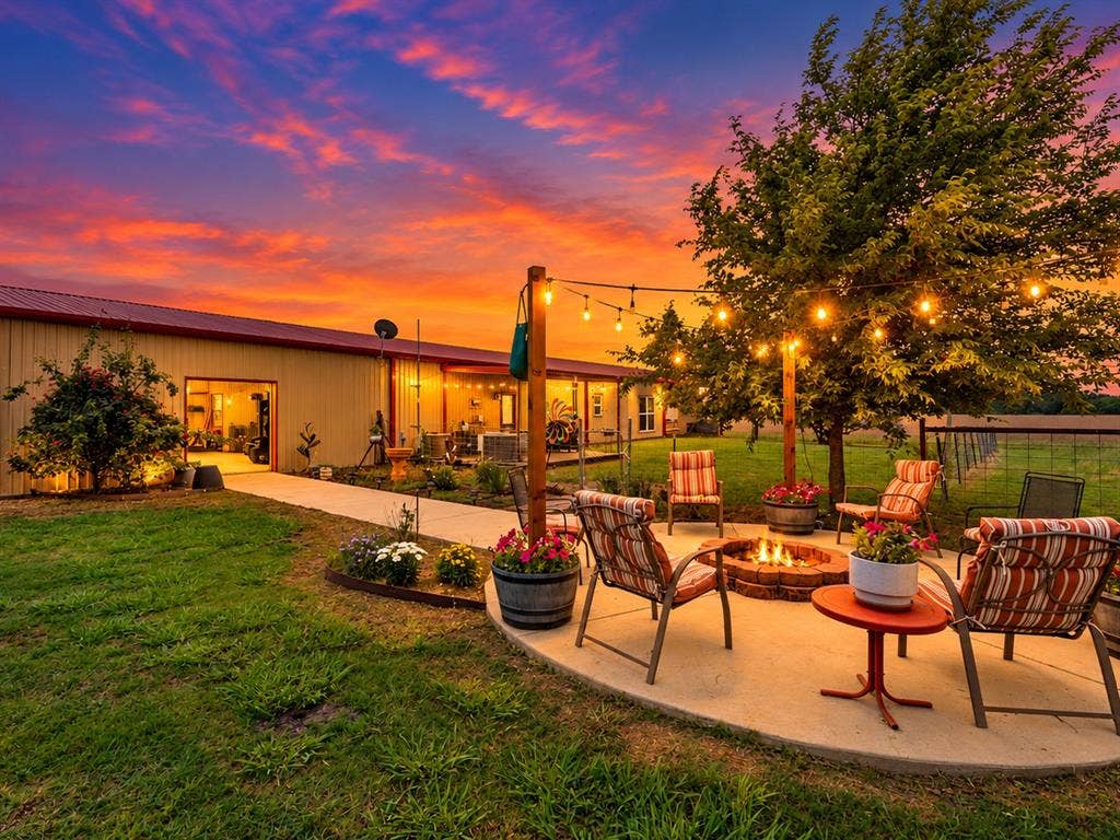 5801 County Road 4128, Scurry, TX 75158 Spacious backyard with a concrete patio, built-in fire pit, string lighting, and mature trees