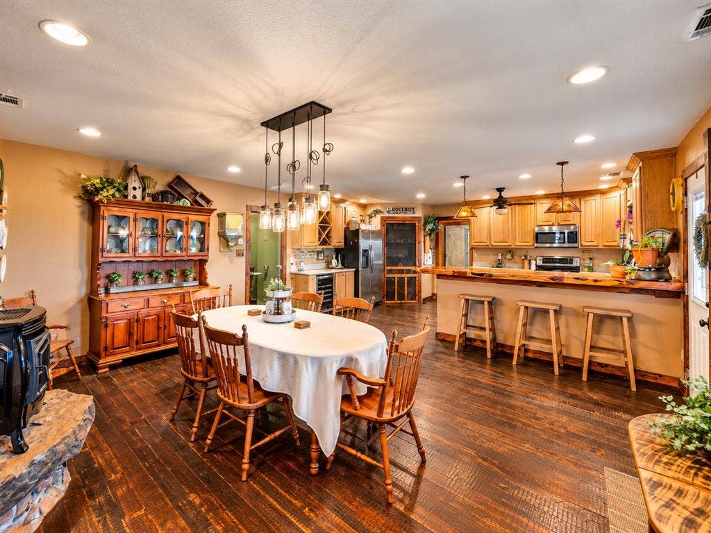 5801 County Road 4128, Scurry, TX 75158 Warm wood-finish flooring complements the kitchen featuring wood cabinetry, stainless steel appliances, and a breakfast bar with wood countertop