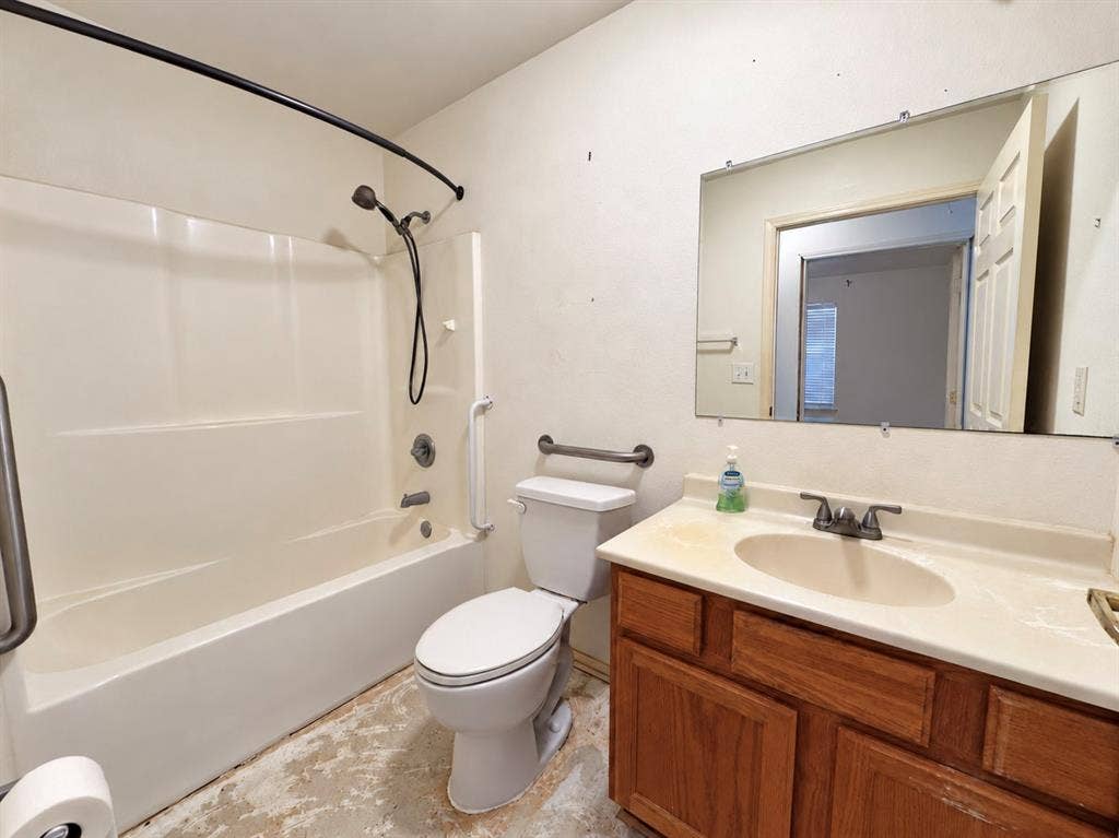 208 Olive Street, Lone Oak, TX 75453 Single vanity with wood-finish cabinetry, integrated sink, and an expansive wall mirror