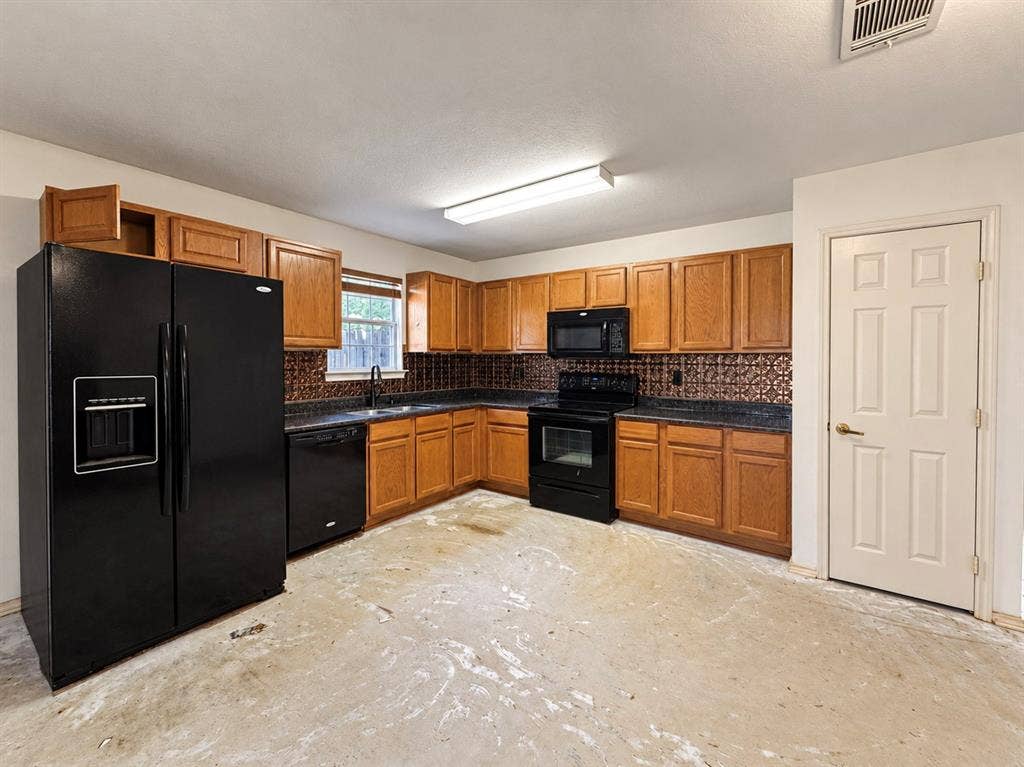 208 Olive Street, Lone Oak, TX 75453 Kitchen featuring wood cabinetry, black appliances, dark countertops, and a patterned tile backsplash