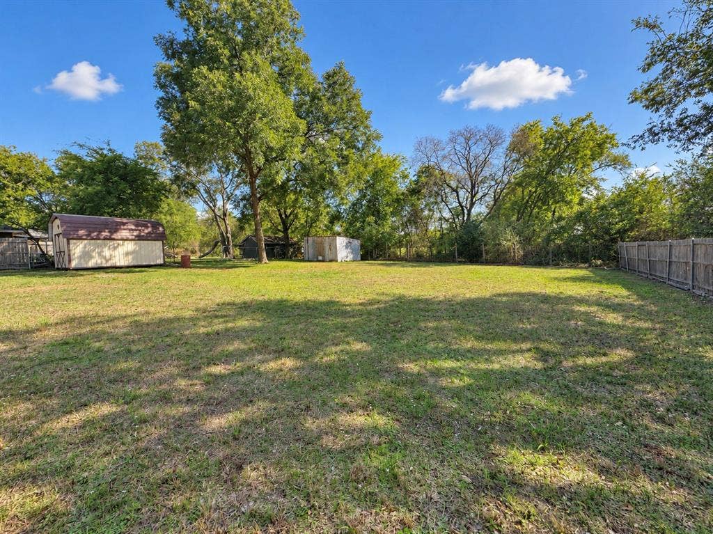 208 Olive Street, Lone Oak, TX 75453 Expansive grassy yard with mature trees and a privacy fence