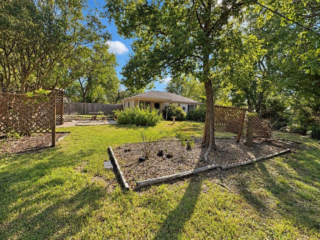 208 Olive Street, Lone Oak, TX 75453 Expansive yard featuring a manicured lawn, established landscaping, and mature trees providing natural shade
