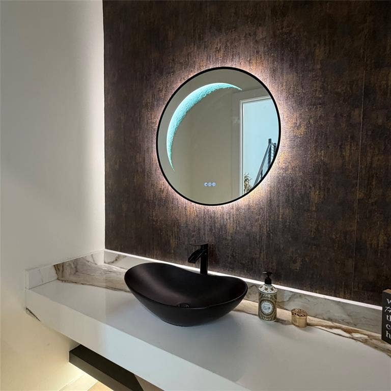 Floating vanity featuring a white surface, matte black oval vessel sink, matching wall-mounted faucet, textured metallic accent wall, and circular LED-backlit mirror