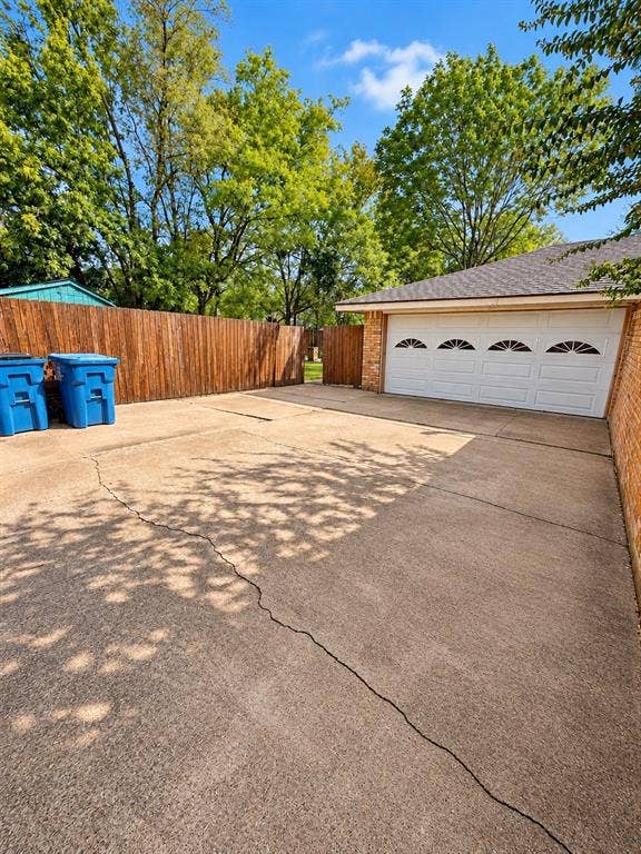 1444 Marlene Place, DeSoto, TX 75115 Concrete driveway, wood privacy fence, brick exterior, four-car garage door