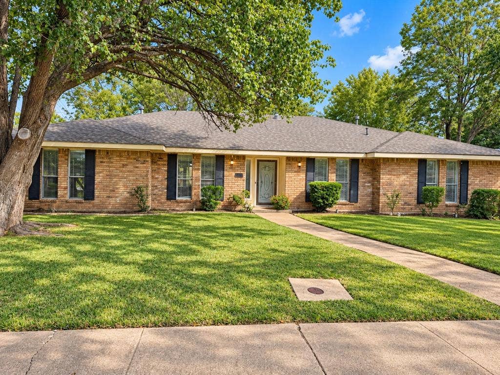 1444 Marlene Place, DeSoto, TX 75115 Brick exterior with dark shutters, a front walkway, and a dark shingle roof